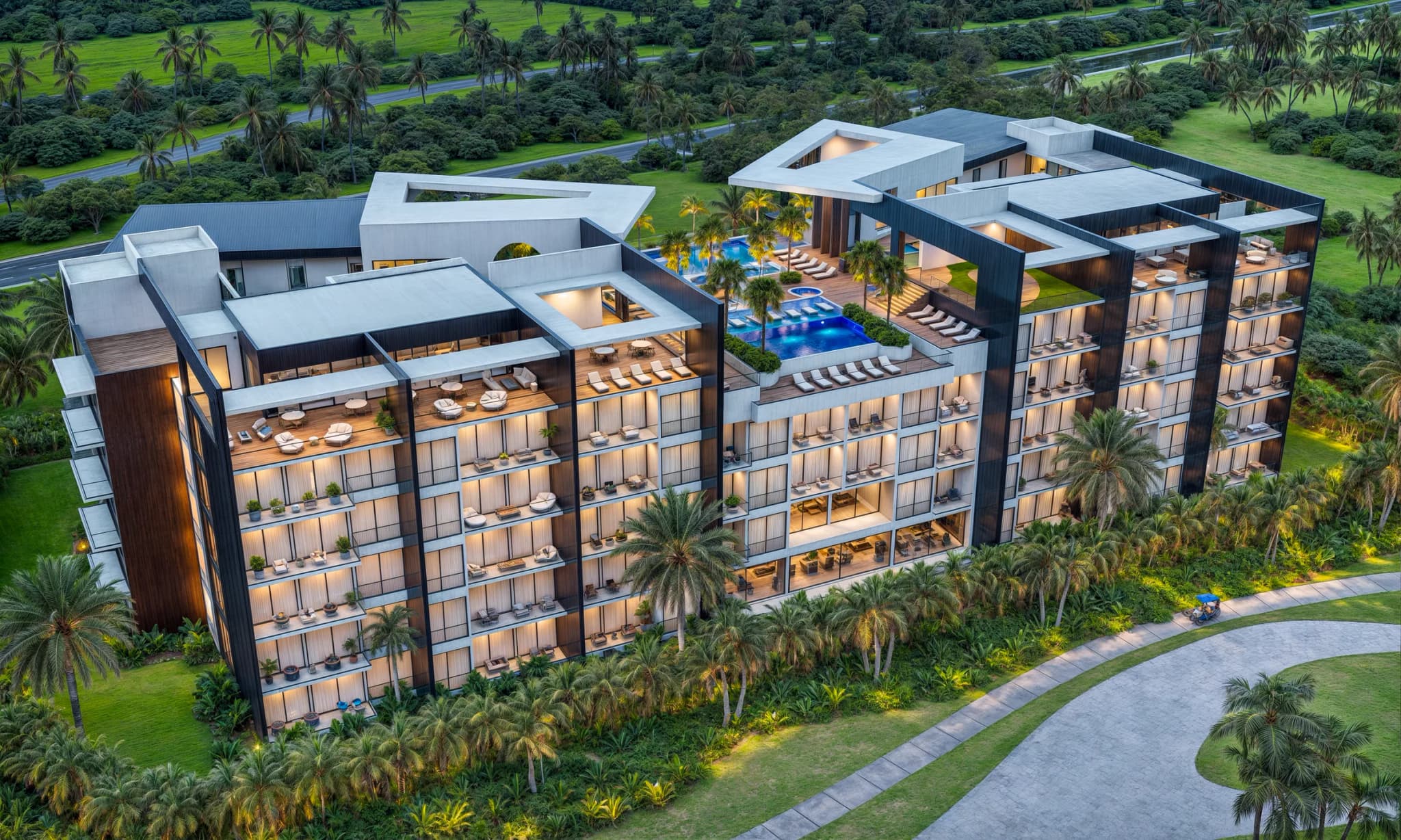 Vista aérea de la fachada posterior, con terrazas en cada apartamento y la piscina en la parte alta