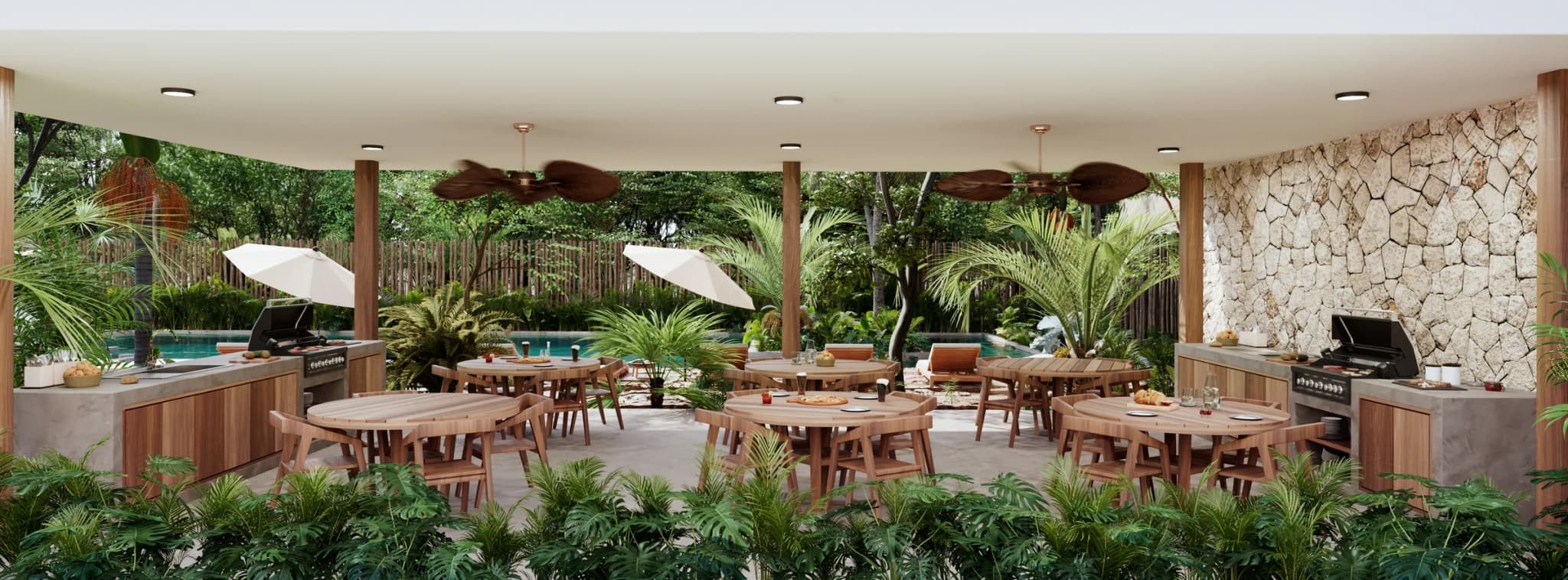 Covered BBQ area with wooden tables, a grill and a stone wall, open to the pool